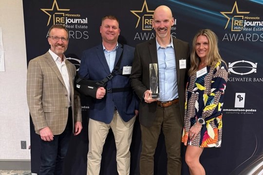 group of men and women holding awards